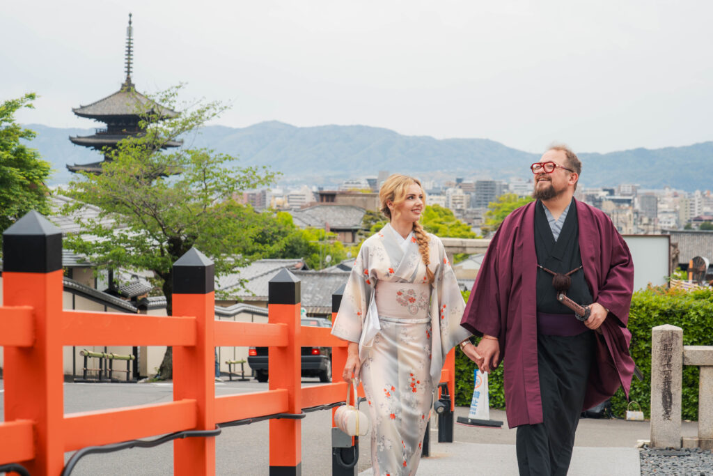 couple in kimono holding hands walking with Yasaka Pagoda in the background